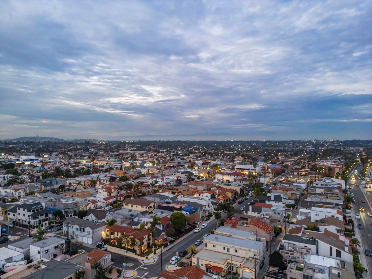 Vista aérea de bairro residencial ao entardecer com ruas e c