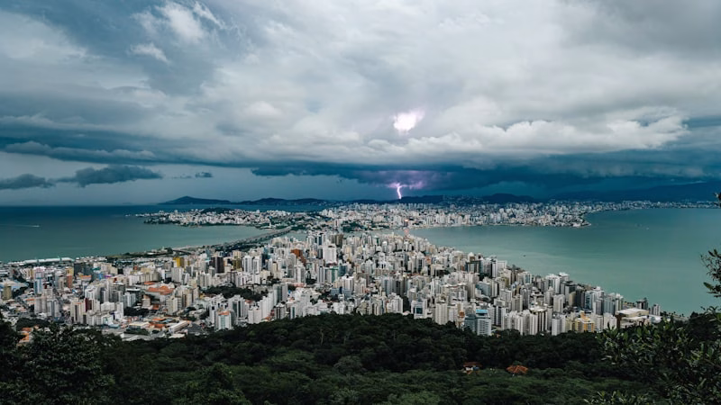 Vista aérea de cidade litorânea, ilustrando o equilíbrio entre tecnologia e qualidade de vida costeira em Florianópolis