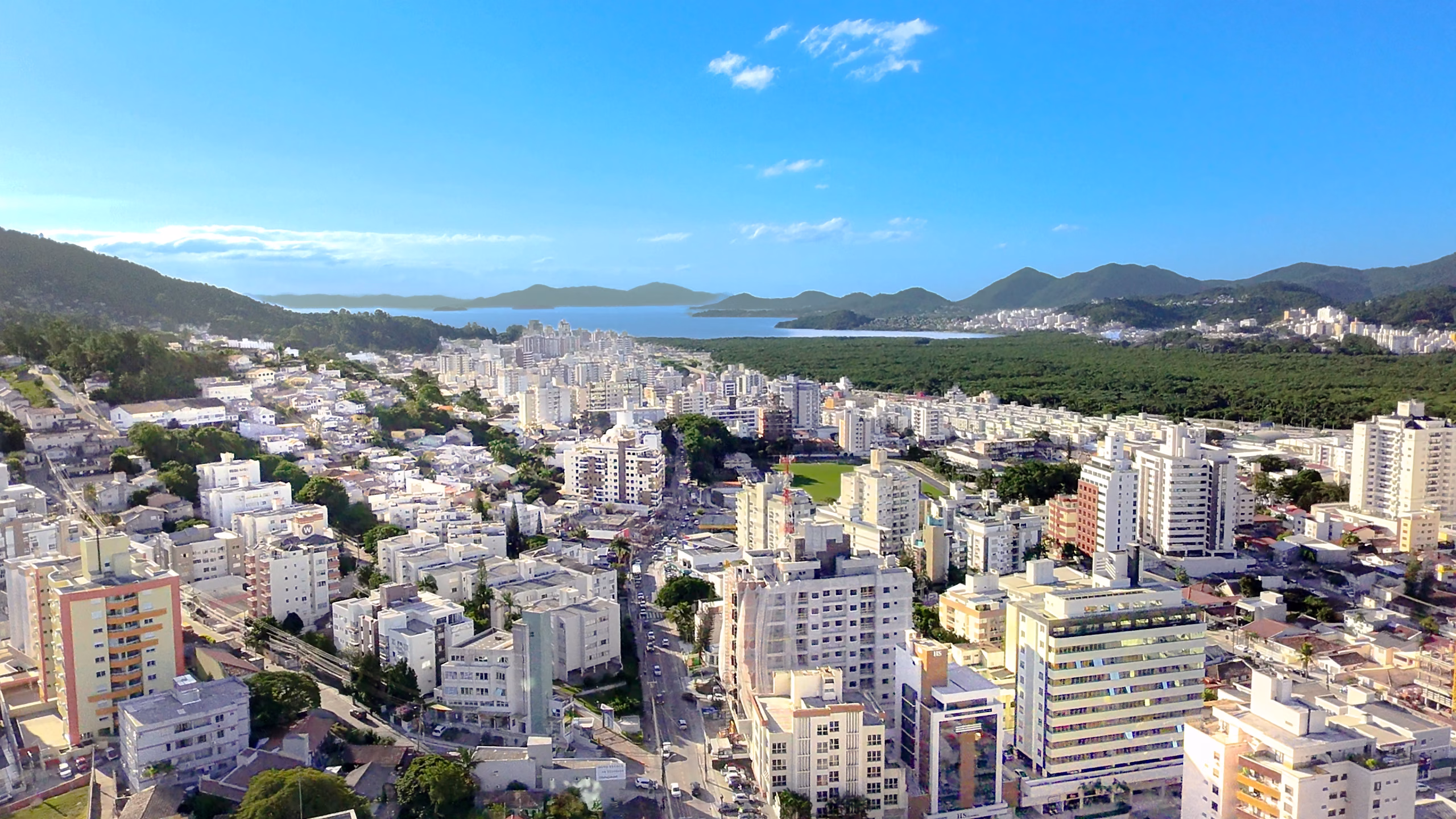 Vista aérea de Florianópolis com baía, morros e área urbana — cenário do turismo esportivo da ilha